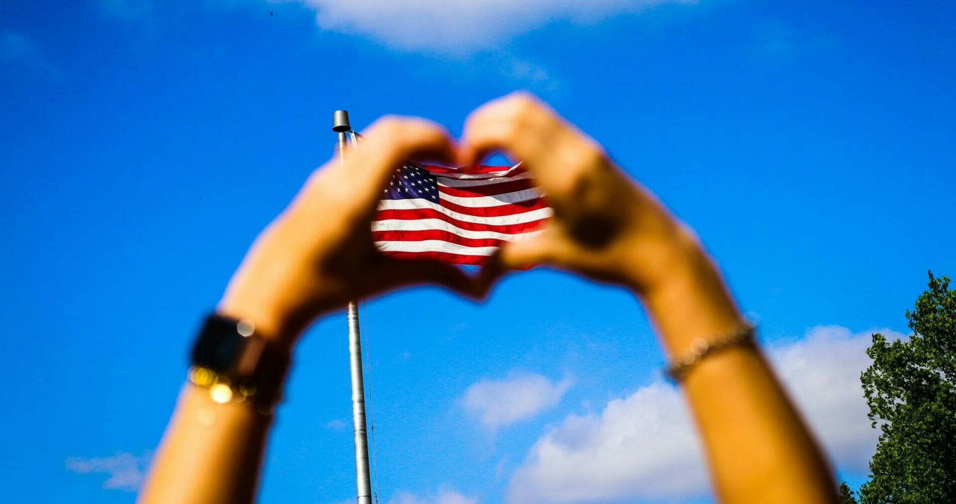 Hand in the shape of heart with American flag in the center. Please Don’t Thank Me – Connect with My Grief.