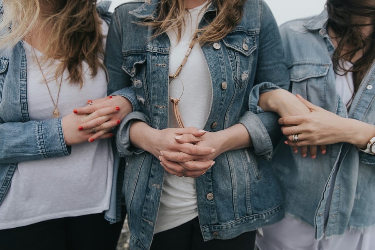 Women linking their arms together