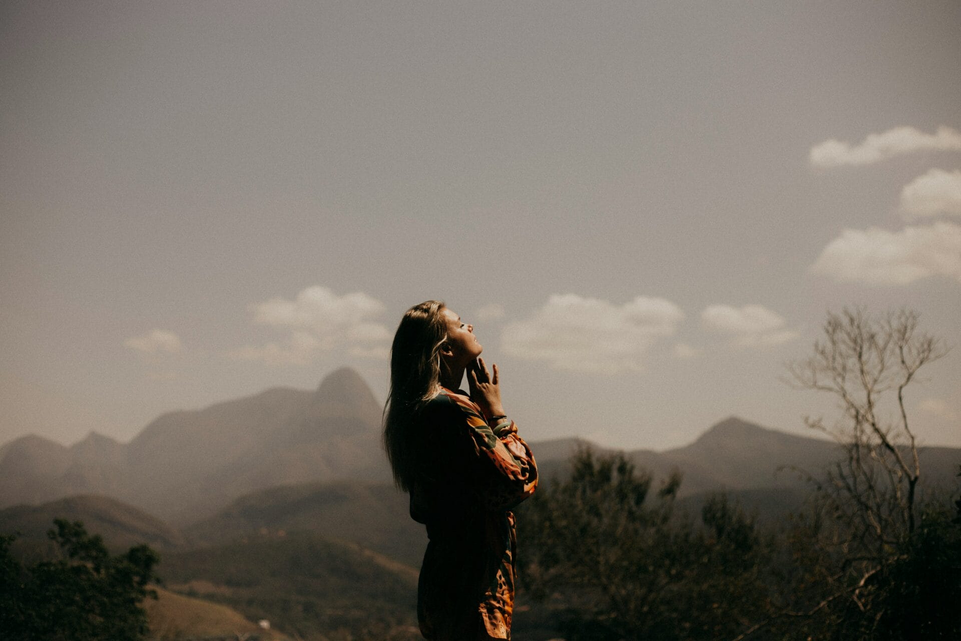 Woman with her eyes closed and looking upward outside with gratitude