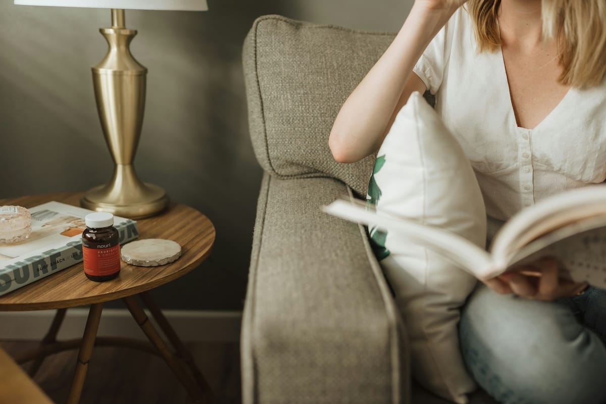 Woman holding a book and sitting on her couch