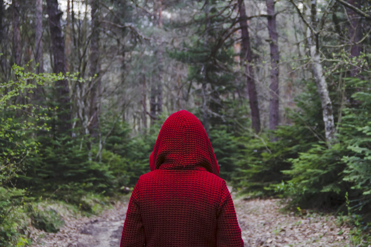 women-in-red-cape-walking-in-woods