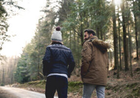 Rear view of couple walking in autumn forest