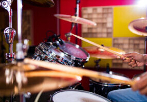 Drummer with Drumsticks in recording studio .